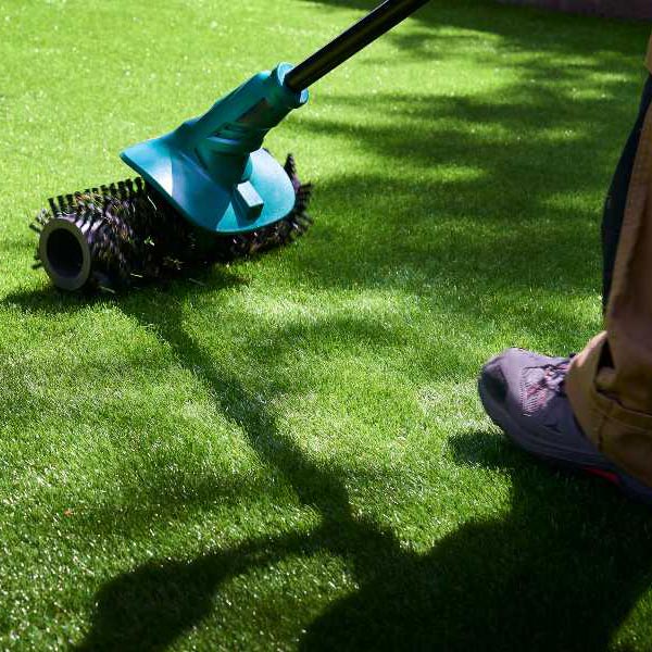 A person operates a lawn mower to trim the grass in a well-maintained yard in Las Vegas, NV.