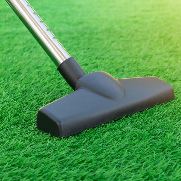 A vacuum cleaner placed on grass, surrounded by a vibrant green backdrop in Las Vegas, NV