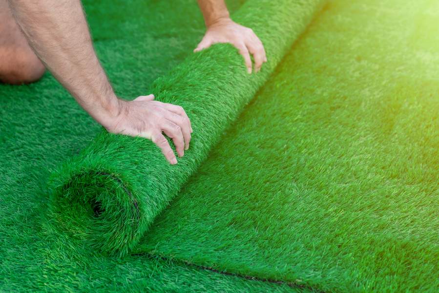 Close-up of a person rolling up an artificial grass turf in Las Vegas, NV 